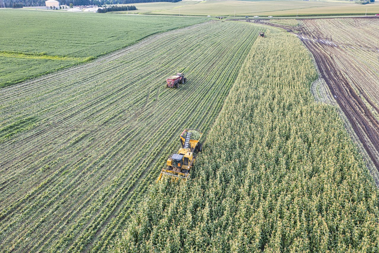 services-02 Drone shot capturing tractors harvesting corn in a rural Minnesota field.