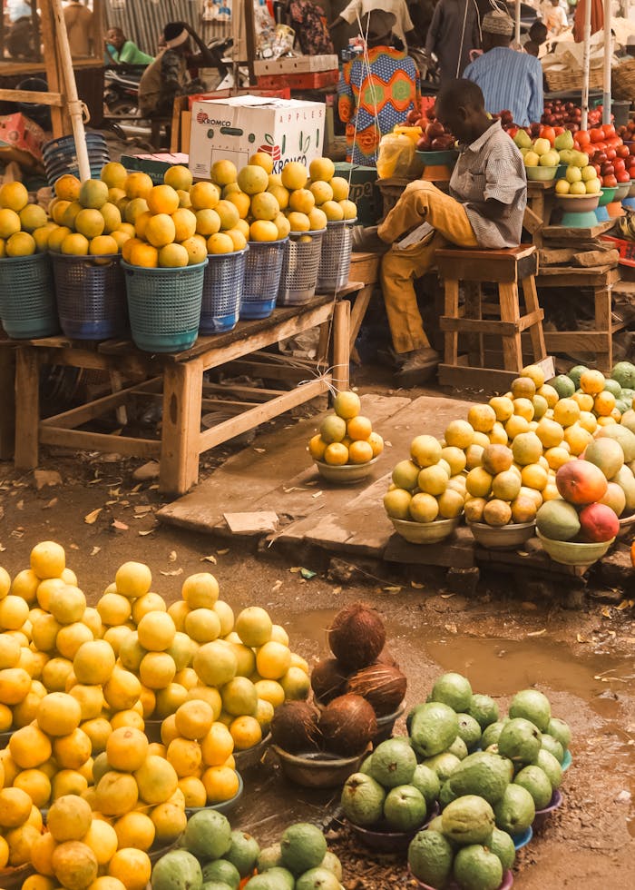 gallery-6 Colorful display of fresh fruits in baskets at a bustling outdoor market.