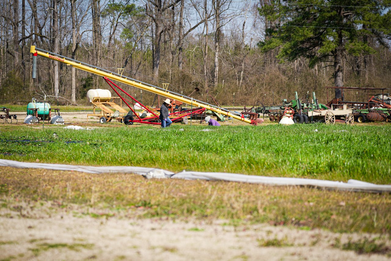 services-01 Rural farm scene in NC with machinery and a worker. Ideal for agriculture themes.